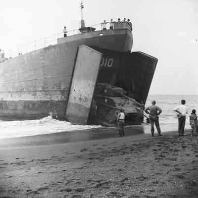 Landing craft unloading a tank onto beach