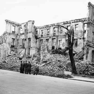 Soldiers standing in front of bombed building