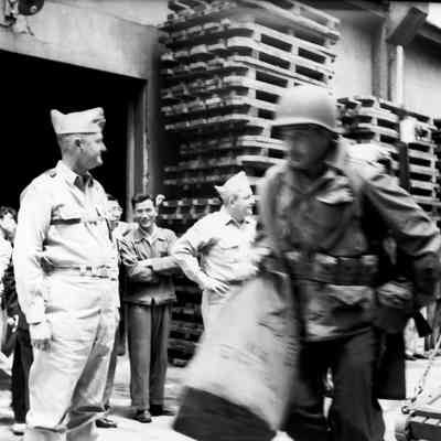 General Styron watching soldiers coming down gangway from ship