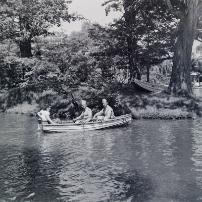 Two soldiers and a civilian woman in a rowboat