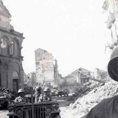 Soldiers driving through ruins