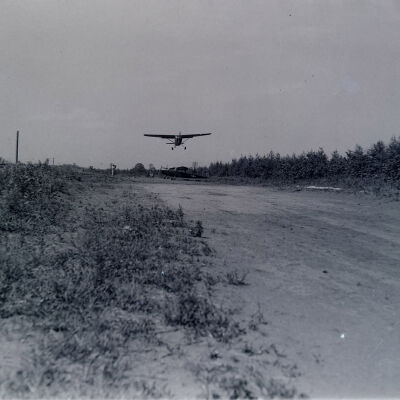 Light observation aircraft landing at airstrip