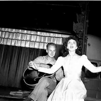 Soldier playing a guitar while a female entertainer sings with him