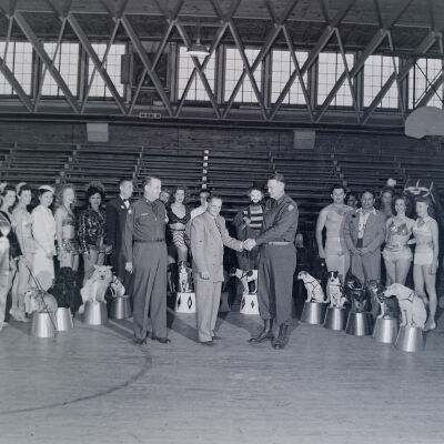 General Styron greeting a circus troupe inside a gymnasium.
