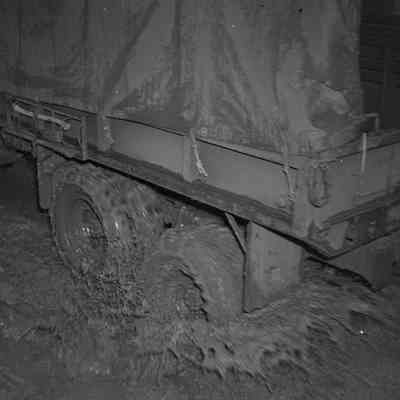 Rear wheels of military truck moving through mud