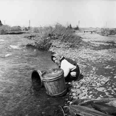 Woman washing at a river's edge