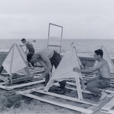 Soldiers erecting signal structures on a beach