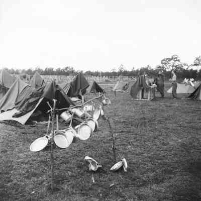 Mess gear hanging out to dry with tent camp in background