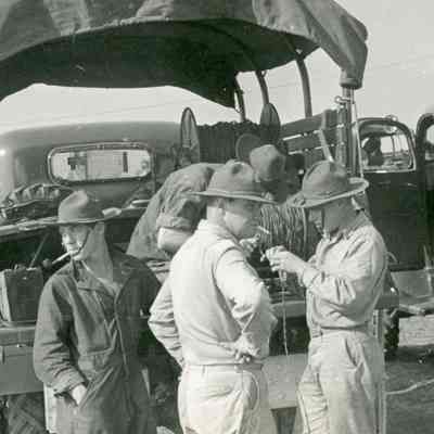 Soldiers spooling communication wire from the back of a truck