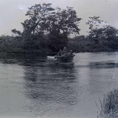 Soldiers in a motorboat on a river