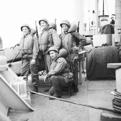 Soldiers on deck wearing life vests and helmets