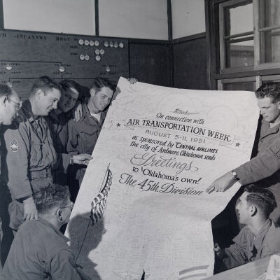 Soldiers holding poster celebrating "Air Transportation Week" sponsored by Central Airlines