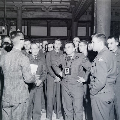 Group of soldiers in a building listening to a tour guide