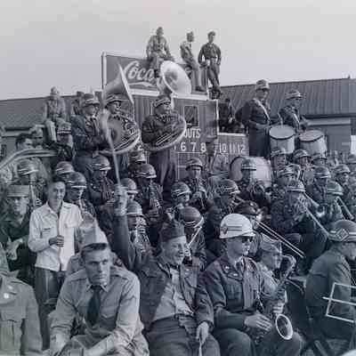 Soldiers and band members gathered around scoreboard
