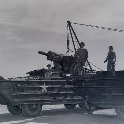 Soldiers loading artillery into DUKW