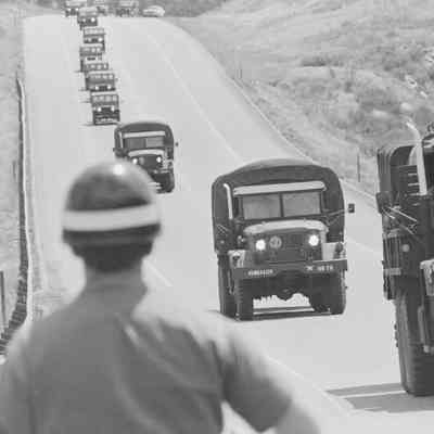 Military Police watches as convoy drives down highway