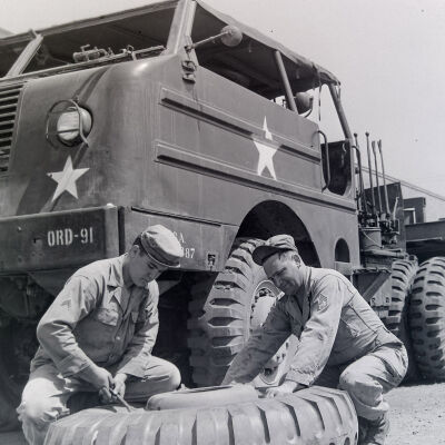 Soldiers changing tire on tank-hauling tractor