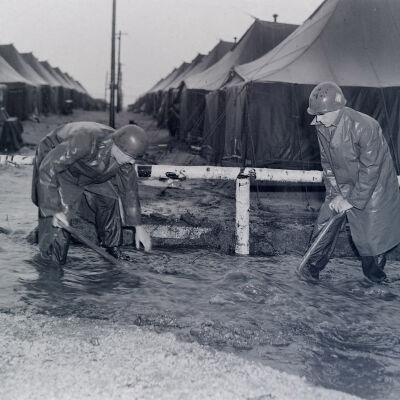 Soldiers clearing debris in a flooded camp area