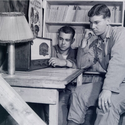 Two soldiers listening to radio in barracks library