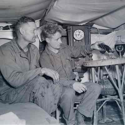 Soldiers pouring wine in a dugout in Anzio