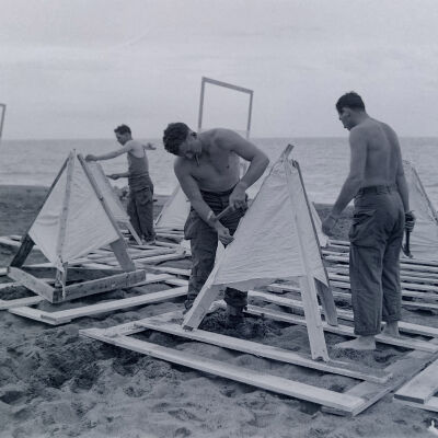 Soldiers erecting signal structures on a beach