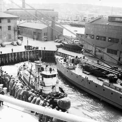 Soldiers on transport ship watching the activity in the dock