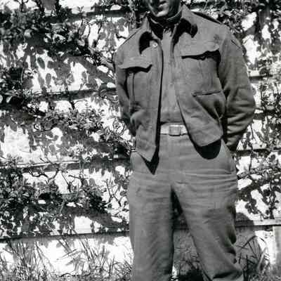 Soldier standing in front of ivy-covered wall