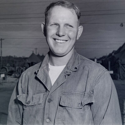 Portrait of unknown soldier with camp area in the background