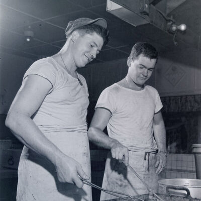 Two soldiers cooking in mess hall