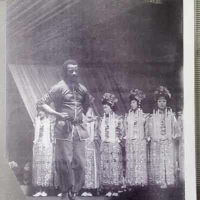 Man in martial arts stance - Chinese opera performers in background