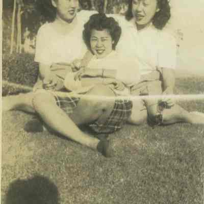 Three young women sitting on the grass