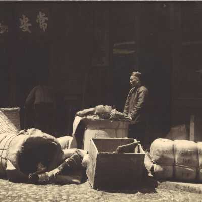 Man with Burlap Sacks and Wooden Containers