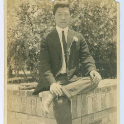 Chinese Man in a Suit and Tie Sitting on a Ledge