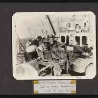 Image of men aboard ship checking machinery to be used on the islands