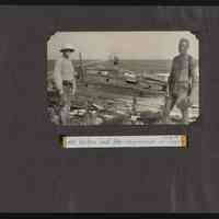 Two men stand in front of the shipwreck of the Amaranth on Jarvis Island
