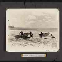 Men bringing supplies ashore unknown island