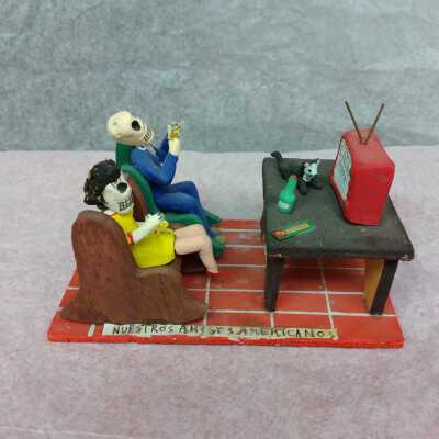 Miniature skeleton couple watching T.V.