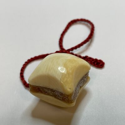 #2: Bone cusBone cushion-shaped waxer on a red twisted cord with wax sandwiched between the two bone cushions