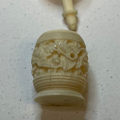 #3: A carved bone barrel-shaped holder container for thread. The top comes off and thread is wound around the attached staff. The bottom barrel-shaped piece is heavily carved