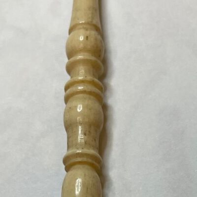 #3: A bone stiletto with a narrow pointed tip with graceful carvings reaching the rounded top
