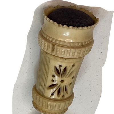 #1: Carved bone table clamp with a red velvet pincushion on the top. There is a flower carved through the bone on the staff.