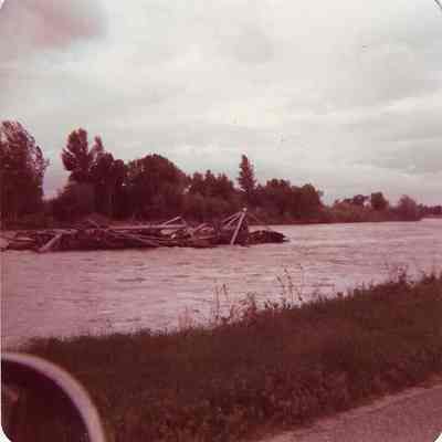 Flooded River with Debri floating down in the middle of the River