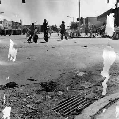 People carrying Lawn Chairs with Flood Debris Towards the Foreground