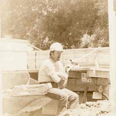 Man In Hard Hat Sitting On Construction Vehicle