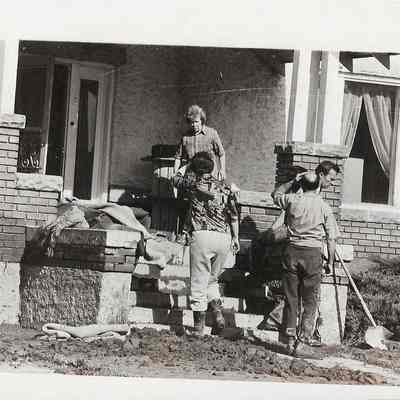 People Removing Mud From Yard