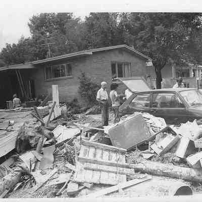 Debris in Front of Home Five People In Frame