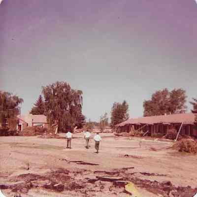 Three Men Evaluating Flood Damage