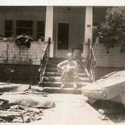 Man Playing Guitar Among Flood Debris