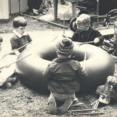 Children drumming on a rubber tube