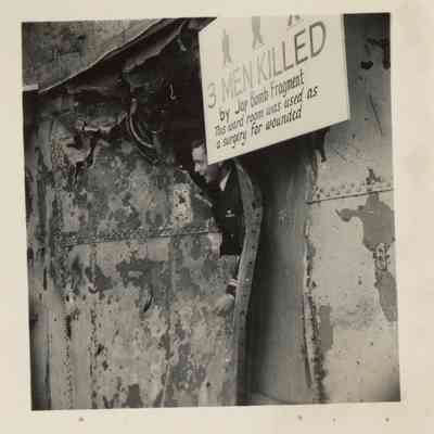 A service member can be seen with his hand sticking through holes ripped through the Laffey's armor.